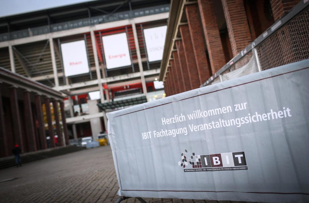 Container mit Willkommensbotschaft zur IBIT-Fachtagung Veranstaltungssicherheit vor einem Veranstaltungsgebäude.