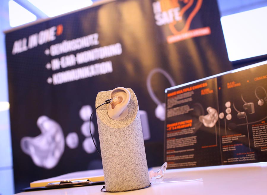 Moderne Kommunikationstechnik für Veranstaltungssicherheit am IBIT-Stand, ergänzt durch Informationsmaterial.