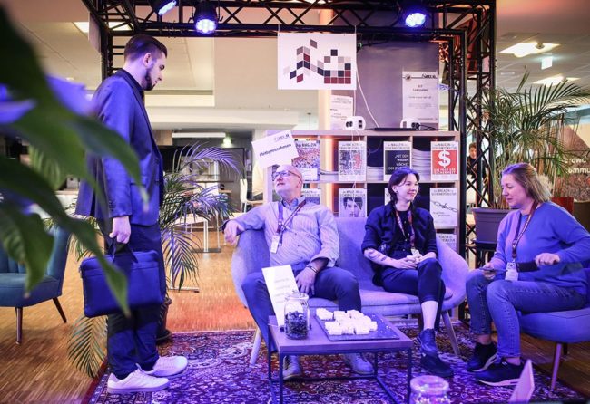 Personen im Gespräch in einer modernen Umgebung, die eine entspannte Atmosphäre ausstrahlt. IBIT.