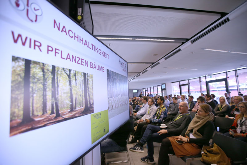 Teilnehmer einer IBIT-Fachtagung Veranstaltungssicherheit verfolgen eine Präsentation zu nachhaltigen Themen in modernem Raum.