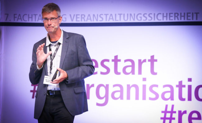 Ein Referent präsentiert auf der IBIT-Fachtagung Veranstaltungssicherheit und diskutiert wichtige Themen.