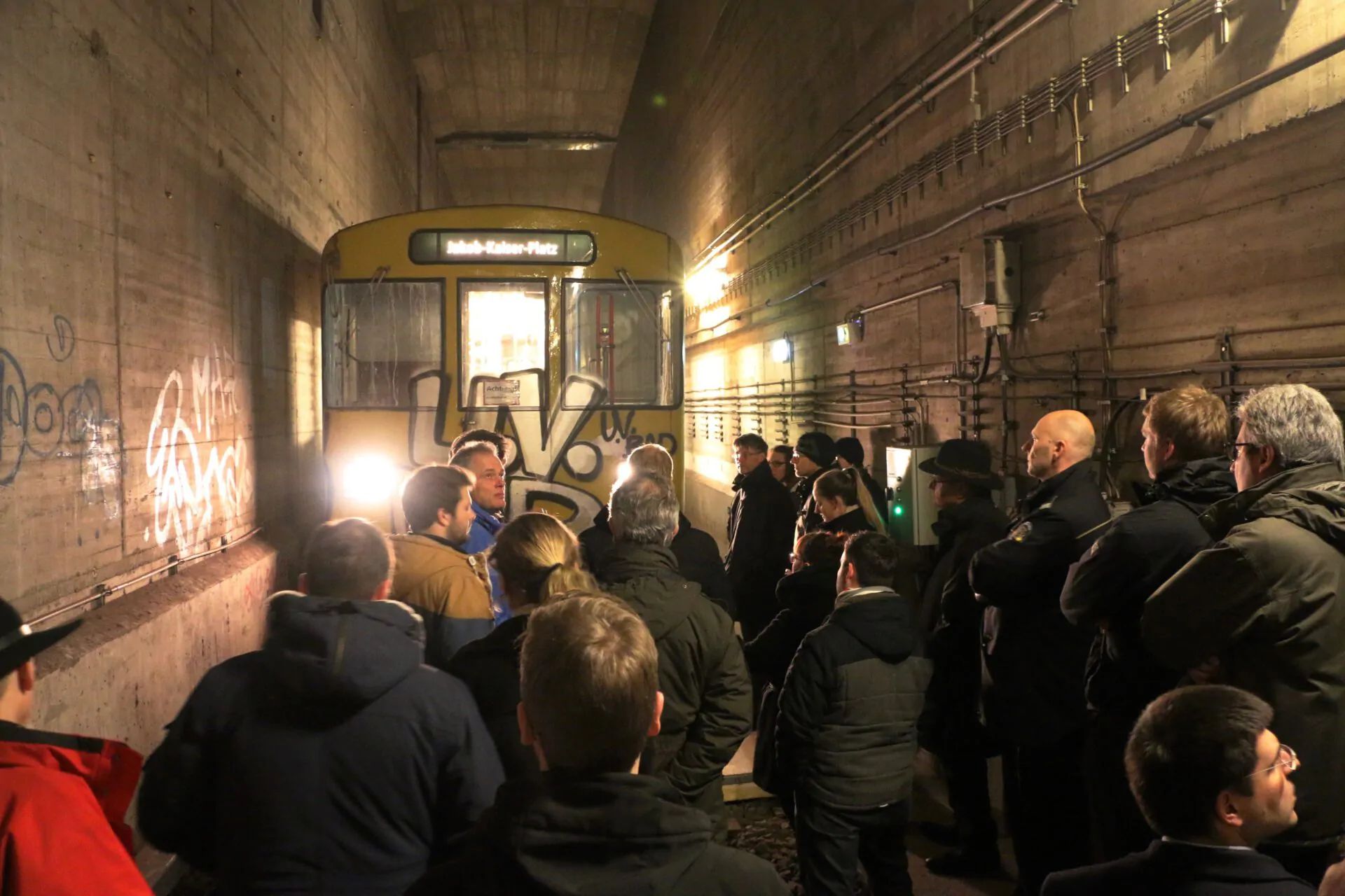 Gruppenschulung im IBIT zur Veranstaltungssicherheit in einer historischen U-Bahn-Station mit einem beleuchteten Zug.