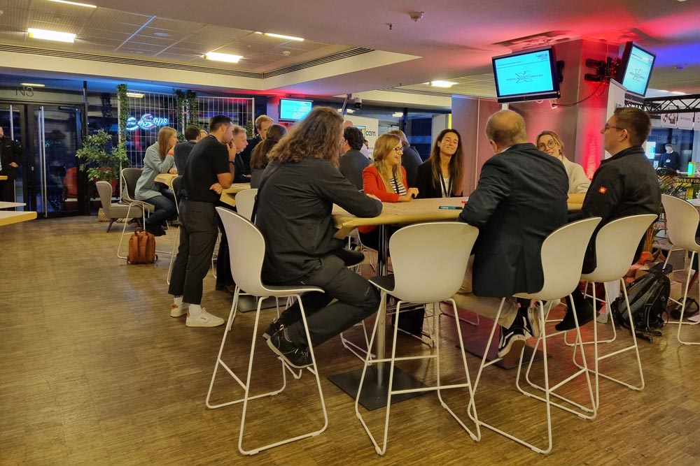 Gruppendiskussion in modernem Raum während einer IBIT-Veranstaltung, Teilnehmer im Austausch zu Veranstaltungssicherheit.