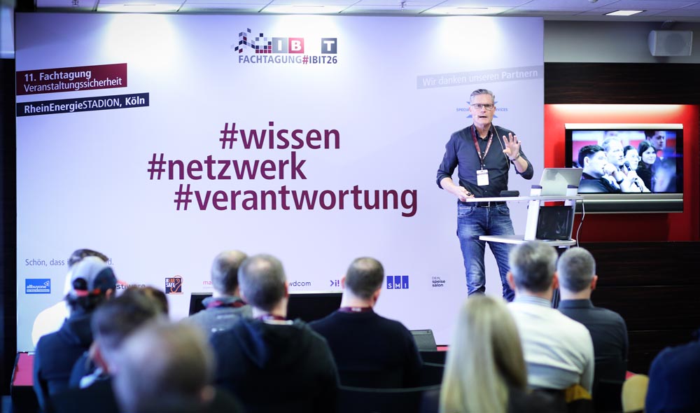 Referent spricht auf der IBIT-Fachtagung Veranstaltungssicherheit vor einem interessierten Publikum im RheinEnergieSTADION.