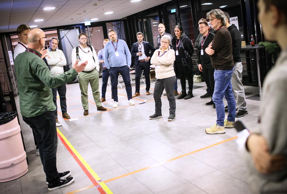 Gruppendiskussion zur Veranstaltungssicherheit in modernem Raum, Teilnehmer hören aufmerksam zu, IBIT-Weiterbildung.