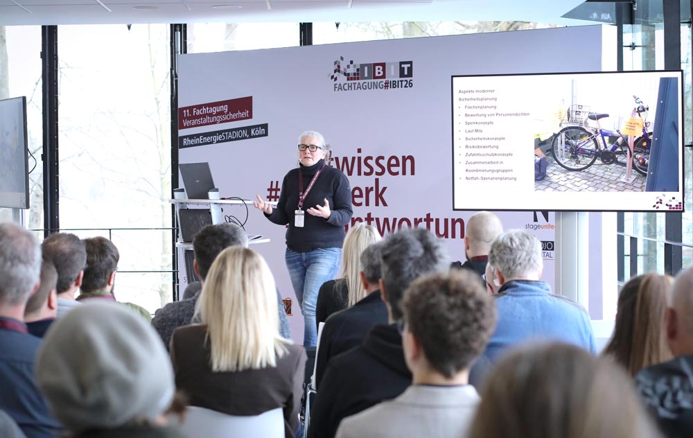 Referent bei der IBIT-Fachtagung Veranstaltungssicherheit erläutert moderne Sicherheitsaspekte vor interessiertem Publikum.