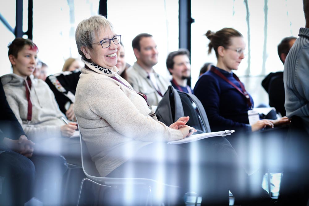 Lächelnde Teilnehmerin in einem Seminarraum während einer IBIT-Weiterbildung zur Veranstaltungssicherheit.